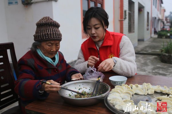 志愿者与老人一起包饺子