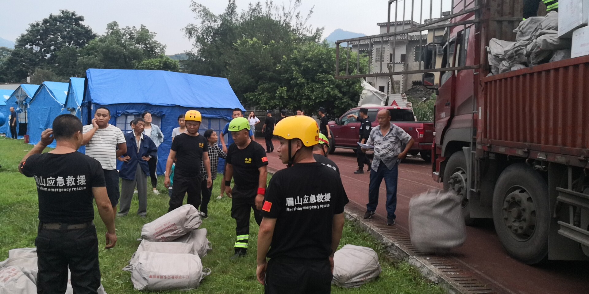 18日晚7时20分左右，救援队员和武警官兵冒雨为群众搬运救灾帐篷。7.jpg