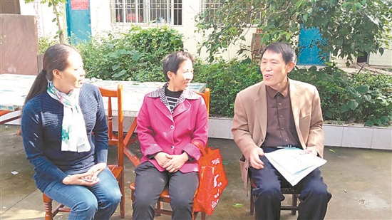 贺仲华（右）向村民宣传柑桔管理技术。