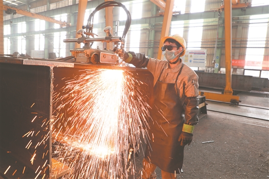 ◀中建钢构四川有限公司生产车间里，工人正在忙生产。.jpg