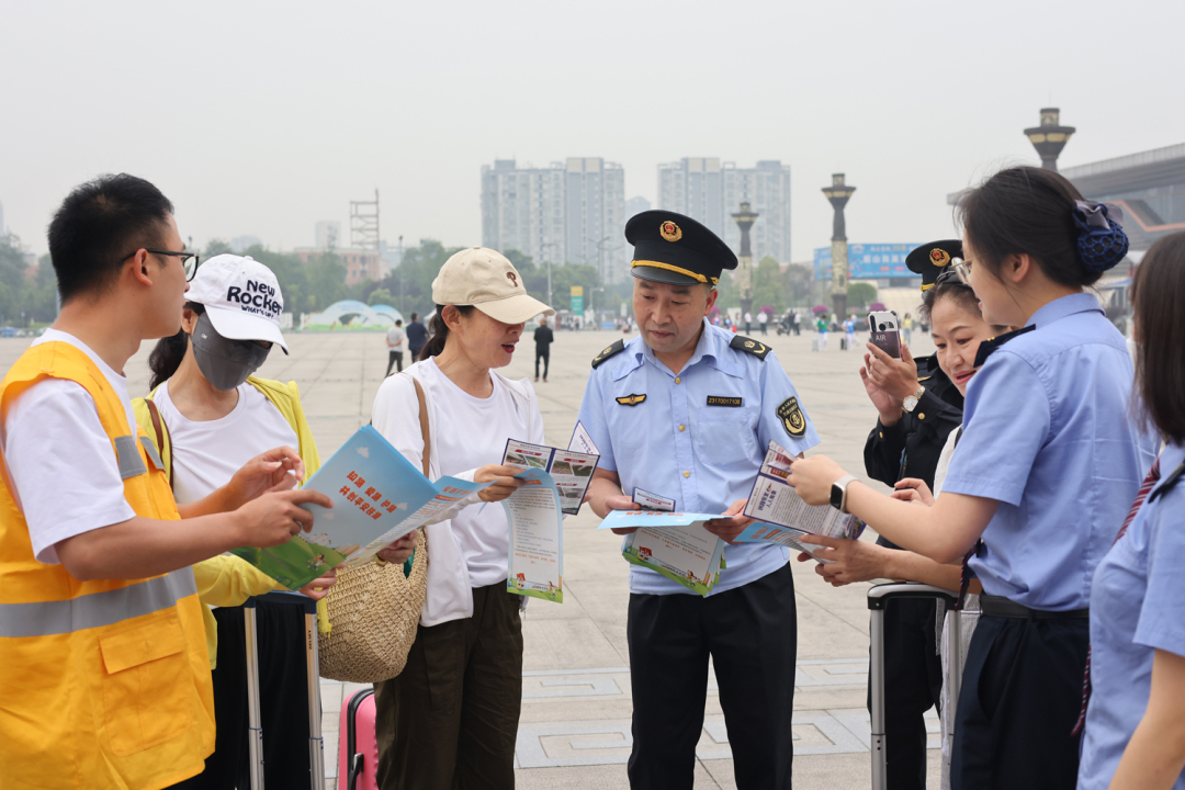 工作人员在眉山东站外向旅客宣传爱护铁路相关知识.JPG