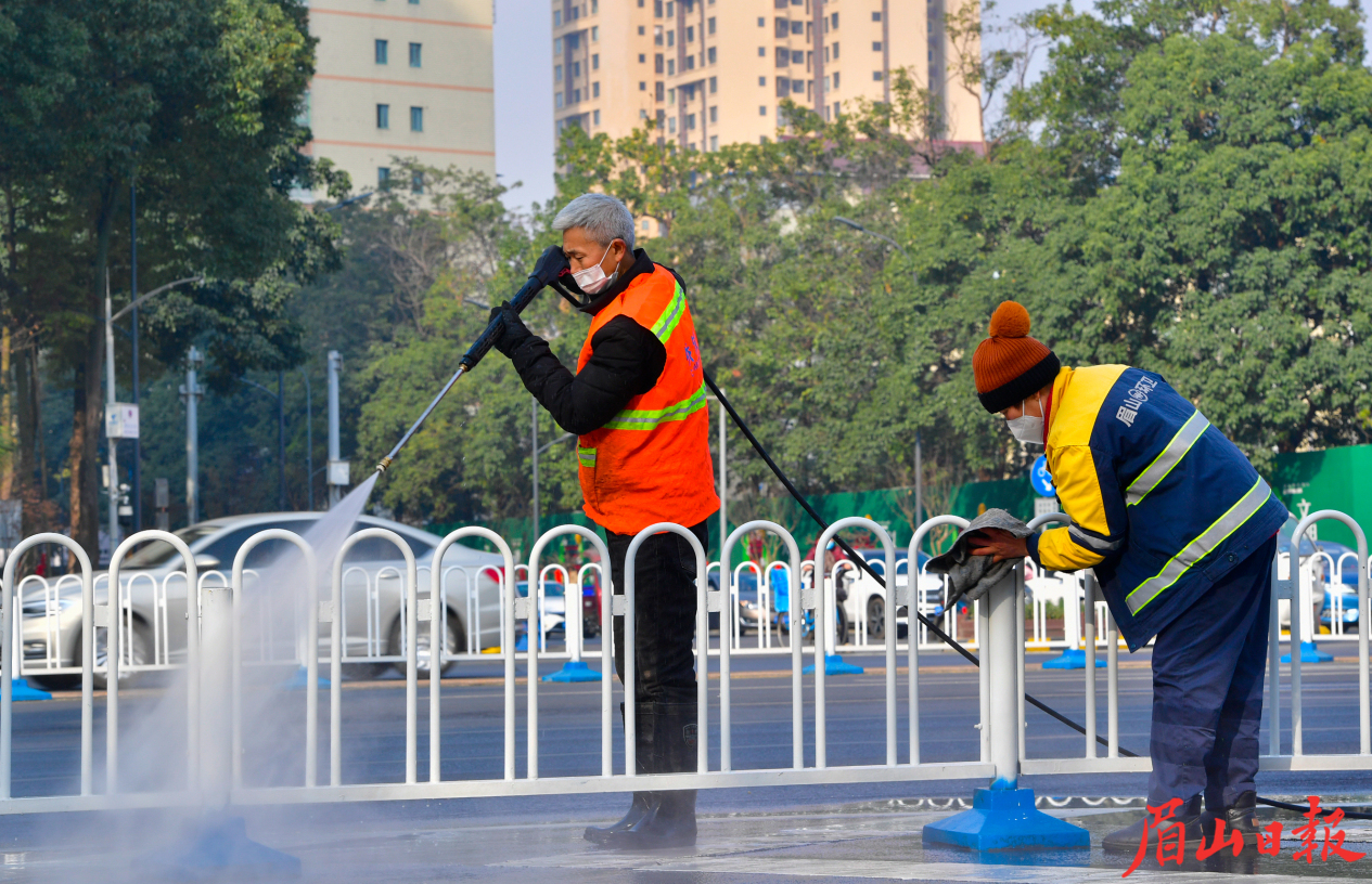 春节期间，环卫工人坚守岗位，为市民提供一个干净的过节环境。图为1月24日，东坡大道环卫工人正在冲洗栅栏。