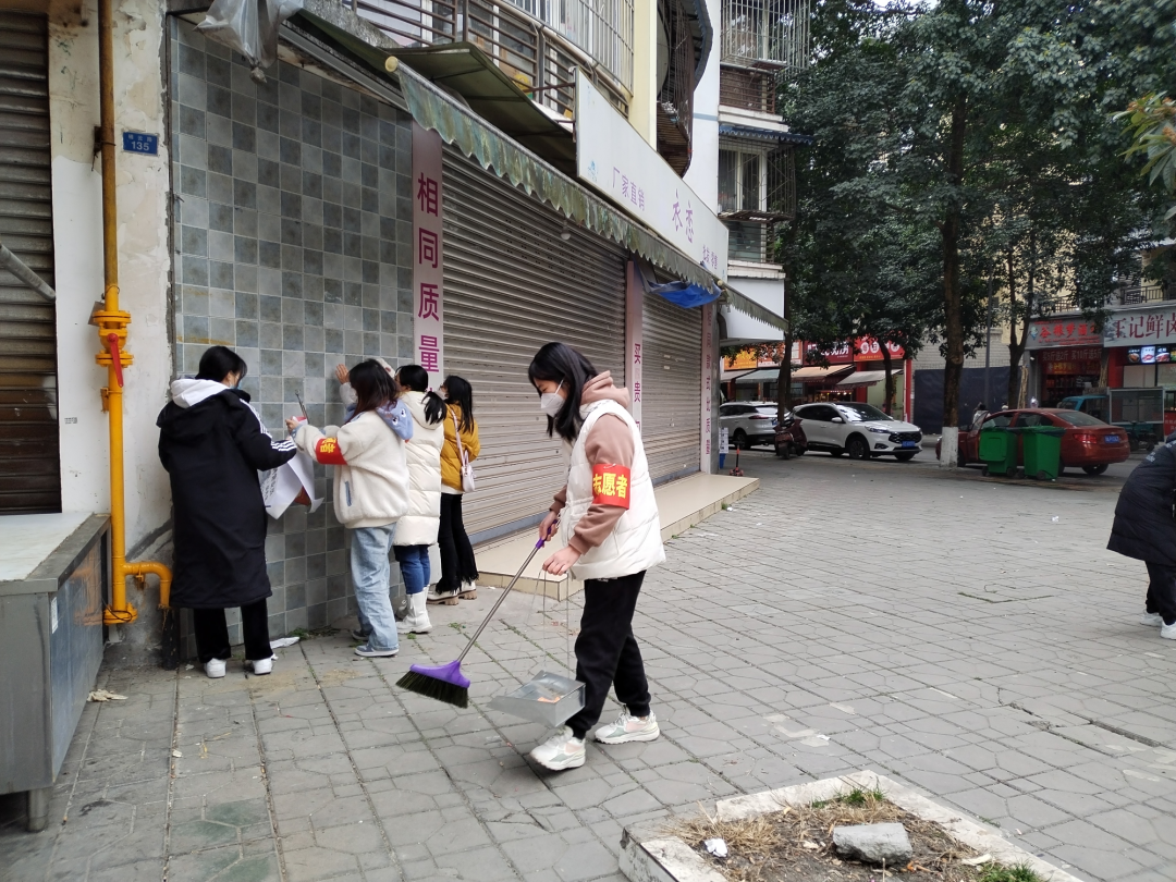 志愿者清理“牛皮癣”和街面垃圾。.jpg