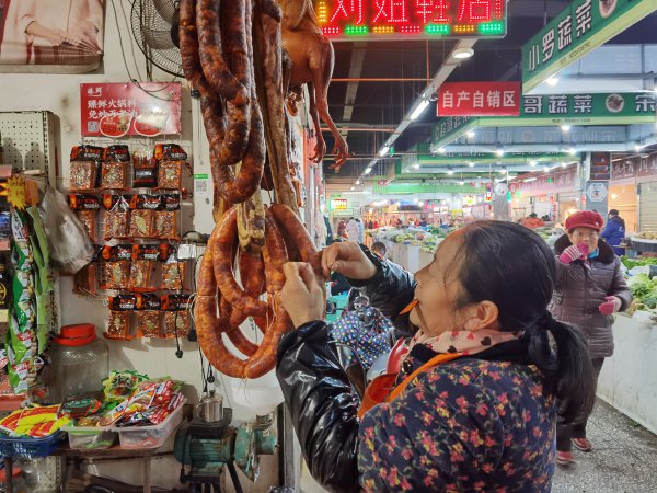 文安农贸市场内，商铺老板正在整理香肠。