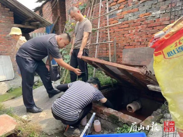 执法人员对该公司下游约10米处雨水沟囤积水进行取样。