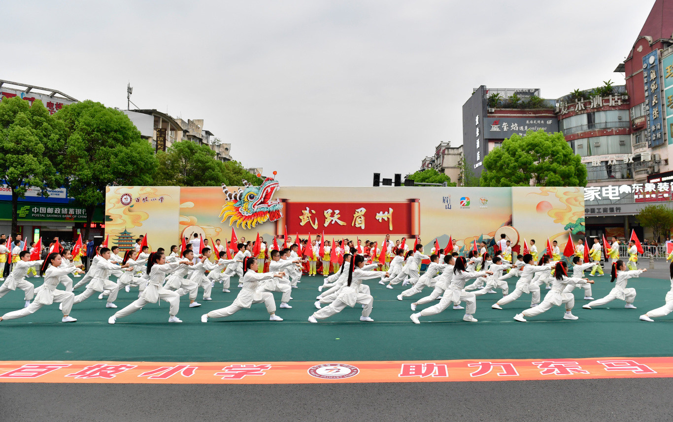 在东坡大道宏远盖丽路口，百坡小学带来的《武跃眉州》，为比赛营造浓厚的氛围。.jpg