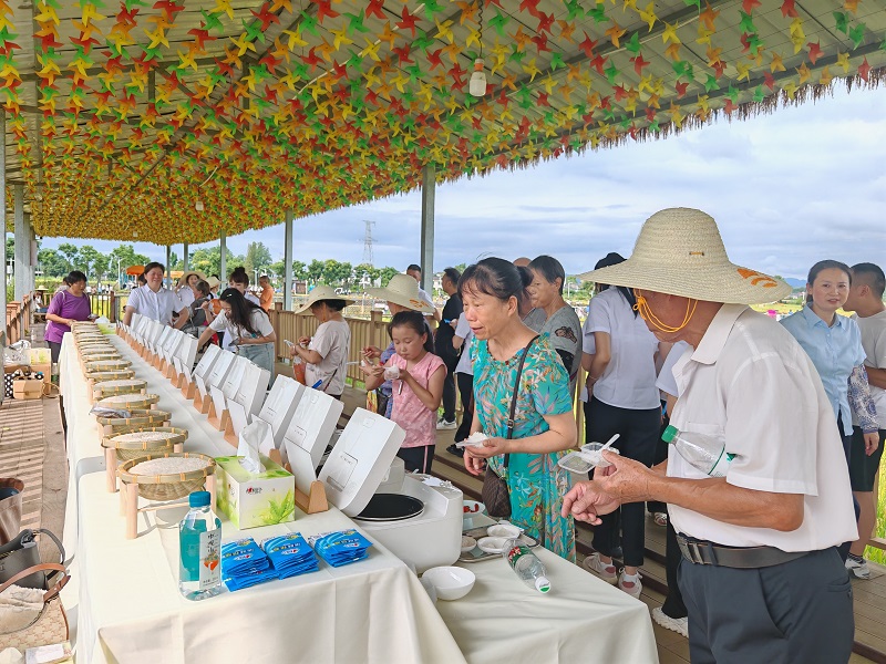  活动现场大米品鉴区，村民正在品尝新品种大米。