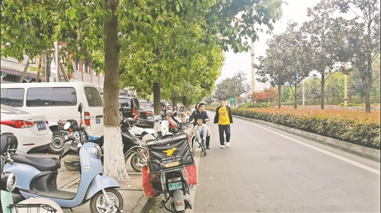 4月4日16点32分：东坡水街，摩托车乱停乱放，市民把小孩放在共享单车筐里。