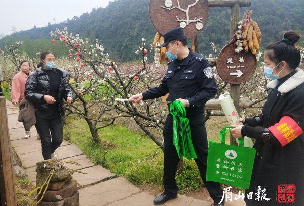  执法民警向游客们发放森林防火相关宣传手册。